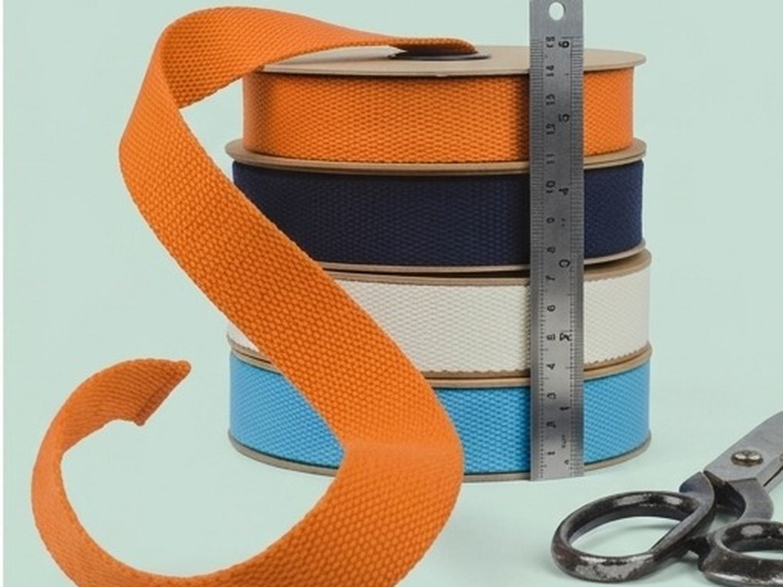 Polyester tape on spools beside a steel ruler